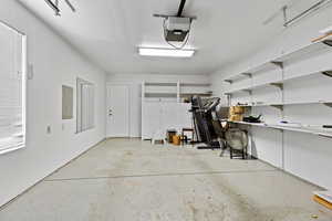 Garage with electric panel and a garage door opener