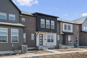 View of front of home featuring brick siding and board and batten siding