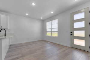 Unfurnished dining area with light wood-type flooring and recessed lighting