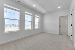 Spare room featuring light colored carpet and recessed lighting