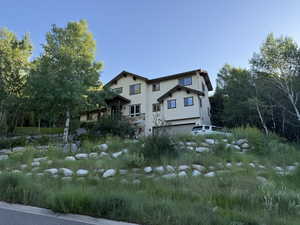 View of property exterior with stucco siding and a garage