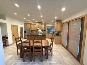 Dining room with recessed lighting, light tile patterned floors, and vaulted ceiling