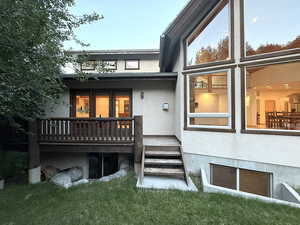 Rear view of house with stucco siding and a wooden deck
