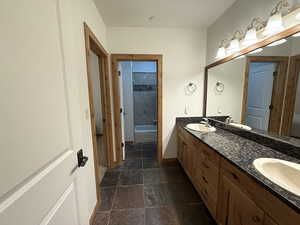 Bathroom featuring double vanity and stone tile flooring