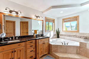 Full bathroom with double vanity, a tub with jets, and tile patterned floors