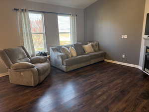 Living room featuring dark wood-type flooring and a fireplace