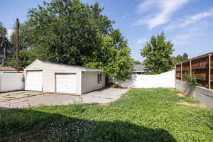 Fenced backyard with an outdoor structure and a detached garage