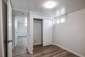 Unfurnished bedroom with wood finished floors and a closet