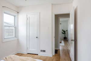 Corridor featuring light wood-style flooring and baseboards