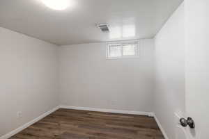 Below grade area with dark wood-style floors and baseboards