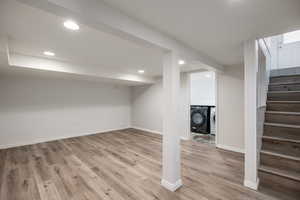 Finished below grade area with washer and dryer, stairs, light wood finished floors, and recessed lighting