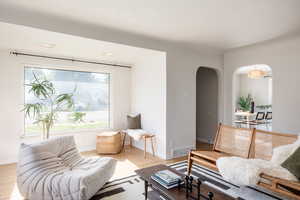 Living room featuring arched walkways and wood finished floors