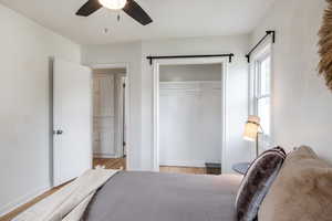 Bedroom with a closet, light wood finished floors, and a ceiling fan