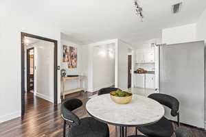 Dining space featuring wood finished floors and rail lighting