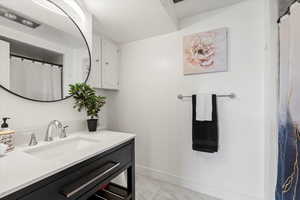 Full bath featuring vanity and marble finish floors