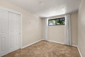 Unfurnished bedroom featuring carpet floors and a textured ceiling