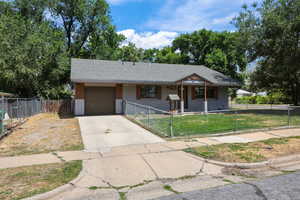 View of front of house featuring driveway, a garage, a fenced front yard, roof with shingles, and a gate