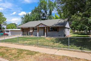 View of front of property featuring brick siding, crawl space, an attached garage, a fenced front yard, and roof with shingles