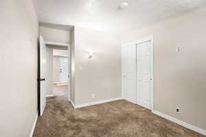 Unfurnished bedroom with carpet flooring and a closet