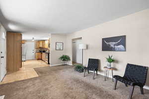Living area featuring light carpet and baseboards