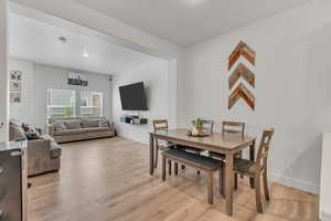 Dining area featuring light wood-style floors and baseboards