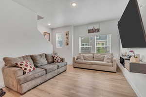 Living room featuring healthy amount of natural light, light wood finished floors, and recessed lighting