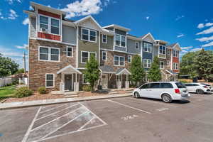 View of property with uncovered parking and a residential view