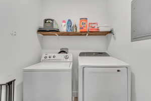 Washroom featuring electric panel and separate washer and dryer