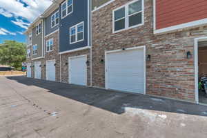 View of building exterior featuring a garage and driveway