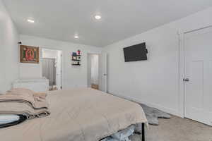Carpeted bedroom featuring recessed lighting and ensuite bath