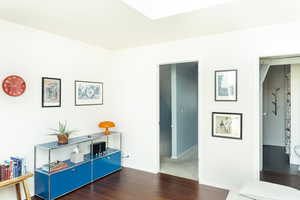 Hallway with dark wood finished floors and baseboards