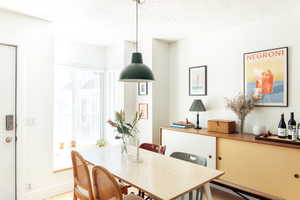 Dining room featuring a textured ceiling and baseboards