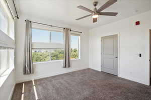 Empty room with a ceiling fan and carpet floors