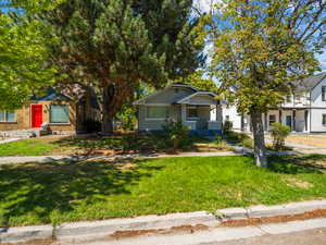 Bungalow-style home with brick siding and a front lawn