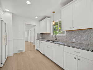 Kitchen featuring decorative backsplash, white cabinetry, white appliances, light stone counters, and recessed lighting