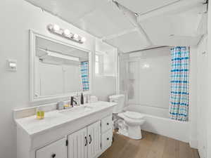 Bathroom featuring vanity, wood finished floors, and shower / bath combo