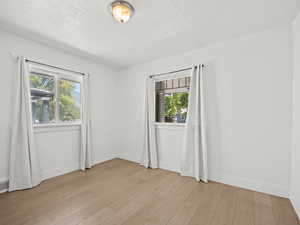 Spare room featuring light wood-type flooring and baseboards