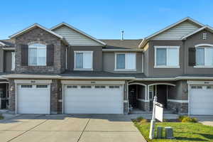 Craftsman inspired home featuring stone siding, concrete driveway, a garage, and a shingled roof