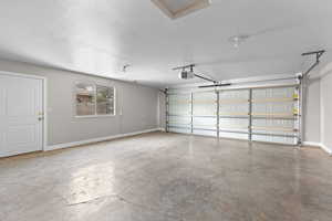 Garage featuring baseboards and a garage door opener