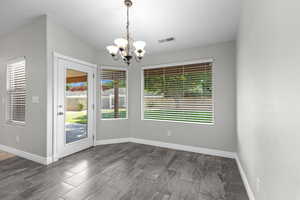 Unfurnished dining area with a chandelier and baseboards