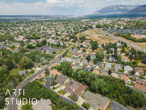 Aerial view of property and surrounding area with a mountain backdrop and nearby suburban area