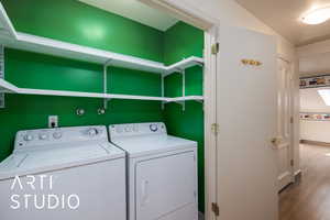 Laundry room featuring washer and dryer and wood finished floors