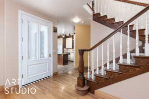 Foyer entrance featuring light wood finished floors and stairway
