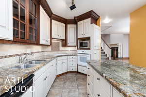 Kitchen featuring oven, tasteful backsplash, dishwasher, and glass insert cabinets