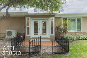 Rear view of property with stucco siding and french doors