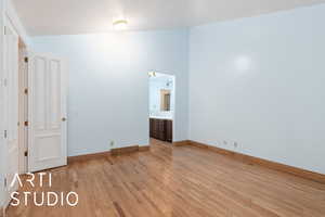 Unfurnished bedroom with light wood-style floors and baseboards