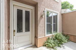 Entrance to property featuring stucco siding