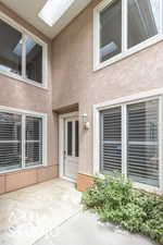 Doorway to property with stucco siding and a patio