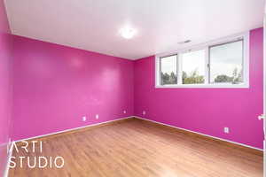 Unfurnished room with wood finished floors and baseboards