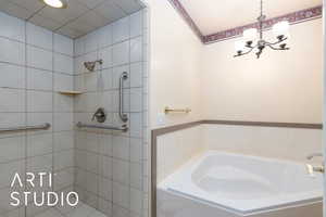 Bathroom with a chandelier, a garden tub, and a tile shower